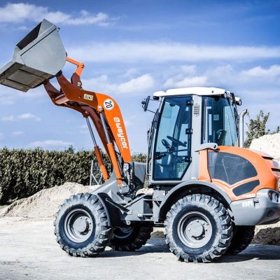 Weycor Radlader mit angehobener Schaufel vor Sandhaufen.