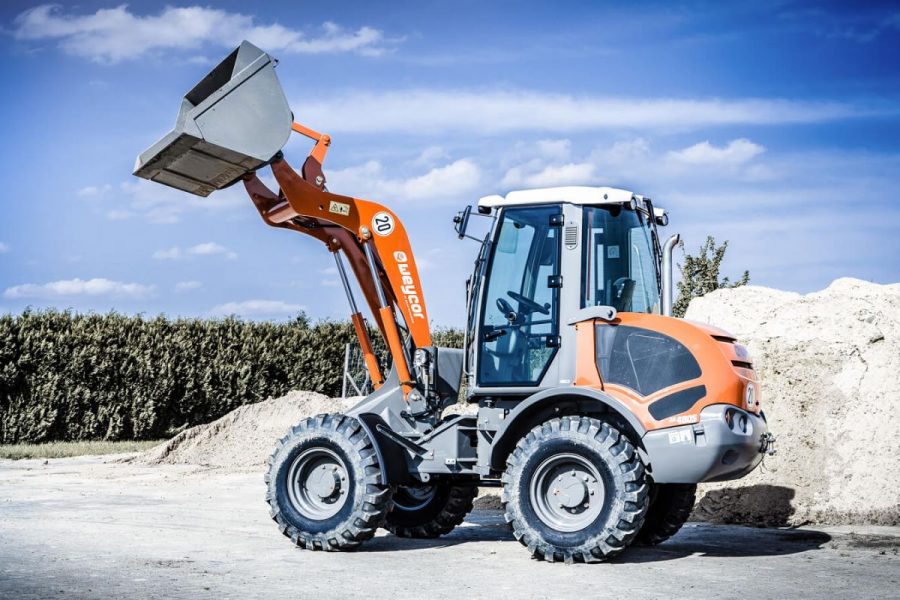 Weycor wheel loader with raised bucket in front of sand pile.