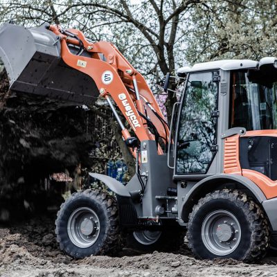 Weycor Radlader AR 520 schüttet Erde auf Baustelle ab.