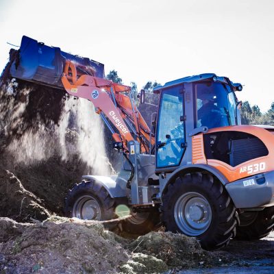 Weycor Radlader AR 530 kippt loses Material von einem Erd- und Komposthaufen ab.